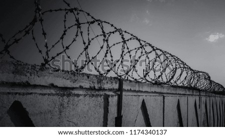 Similar – Fence with a barbed