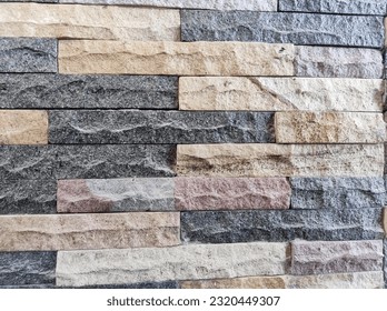 The stone wall cladding is made of white piled stones with brown and black stone inserts. Background, close up
