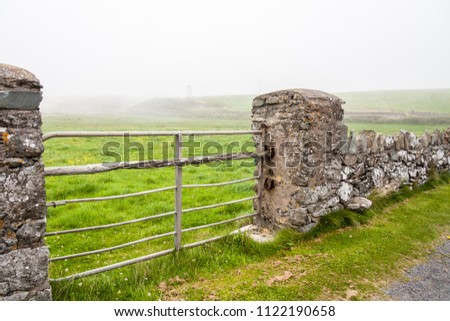 Stone wall and gate in mist  Annestown Ireland