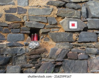 A stone wall and a niche with candles in it