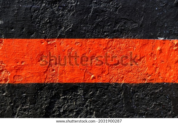 stone wall painted with black paint with a\
red stripe in the middle. High quality\
photo