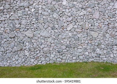 Stone Wall And Slope Grass Below Background