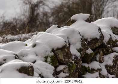 Stone Wall In The Snow Covered Field Close Up