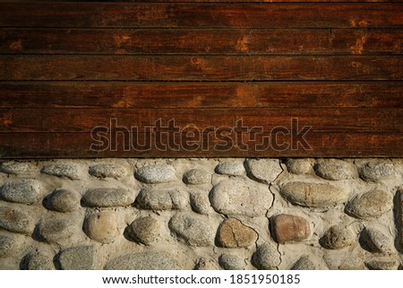 stone and wooden wall background in the rays of the setting sun