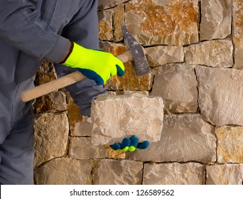 Stonecutter Mason With Hammer And Stone Building A Masonry Stone Wall