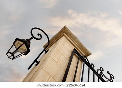 Stoned pillar and wrought iron gate of a wine castle