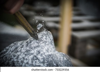 Stonemason With Hammer And Chisel Working On Stone