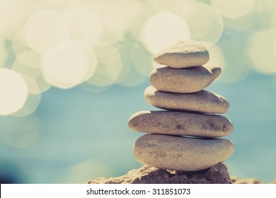 Stones balance at the vintage beach, inspirational summer landscape. Stability hierarchy stack over blue sea in Croatia. Spa or well-being, freedom and stability concept on rocks.