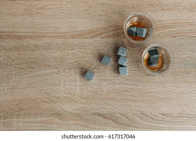 Stones for cooling whiskey and glases tulup on light wooden background