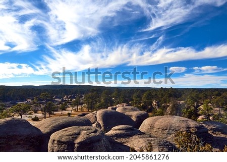 stones with forest in the background and some clouds in a blue sky, mexiquillo durango, mexico
