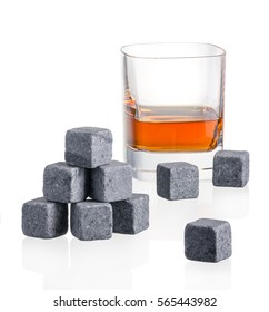 Stones in glass of whiskey on white background