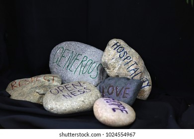 Stones With Morals. Respect Hospitality Openness Hope Love Generosity Arrangement Of Rocks With Text Handwritten On Them. Black Background. Religious Christian Values For Liturgy Liturgies Ceremonies