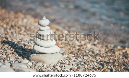 Stones piramide on pebble beach - harmony, meditation, patience and peace of mind concept