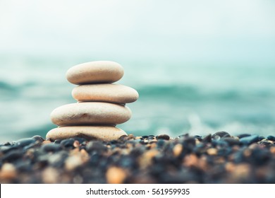 Stones pyramid on pebble beach symbolizing stability, zen, harmony, balance. Shallow depth of field. - Powered by Shutterstock