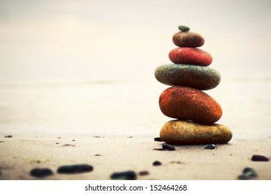 Stones pyramid on sand symbolizing zen, harmony, balance. Ocean in the background