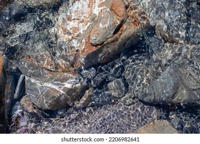 Stones Under Water. Glare Of Water On Rocks