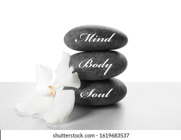 Stones with words MIND, BODY, SOUL and orchid flower on light background. Zen lifestyle - Shutterstock ID 1619683537