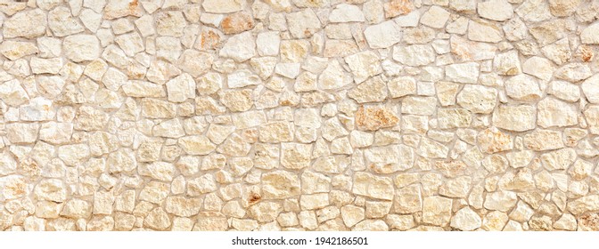 Stonewall background texture. Cobblestone empty with row of beige strong stones 