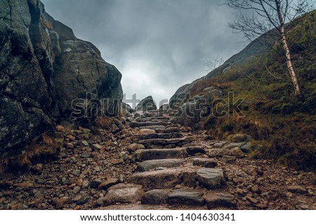 Stony path through the cliffs. Stony hiking trail in the mountains.