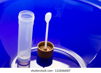 Stool Sample Cup With Collection Spoon On Blue Background