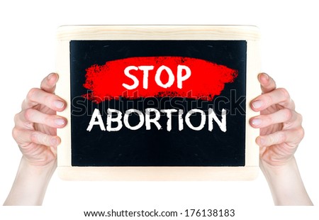 Stop abortion. Creative composition with the message Stop abortion woman hold on blackboard