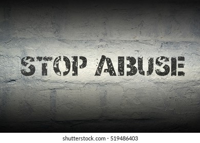 stop abuse stencil print on the grunge white brick wall