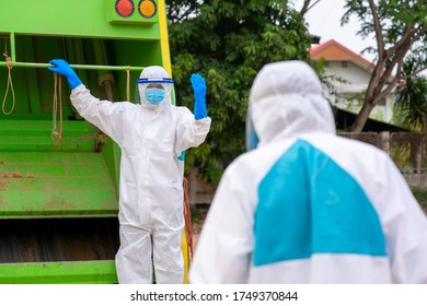 Stop Biohazard,Garbage Men In Coronavirus Hazmats Working Together On Emptying Dustbins For Trash Removal With Truck Loading Waste And Trash Bin.