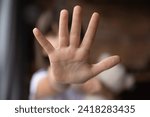 Stop. Blurred shot of little girl stretch hand show no sign mean prepare enough domestic violence bullying abuse violation of children rights. Close up focus on child palm making prohibition gesture