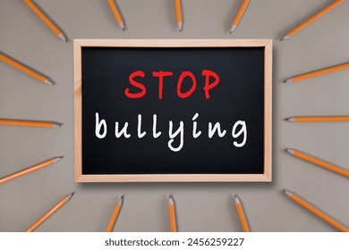 Stop bullying. Inscription with chalk on black school board. Anti-bullying text on backdrop of pencils. Concept of happy childhood, protecting children from physical and psychological bully - Powered by Shutterstock