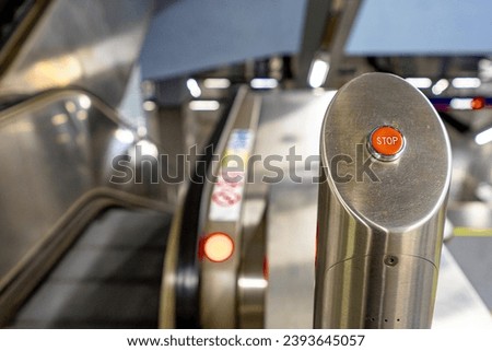 STOP button for immobilizing escalators.  Button on the right side.  Stairs blurred on the left side.