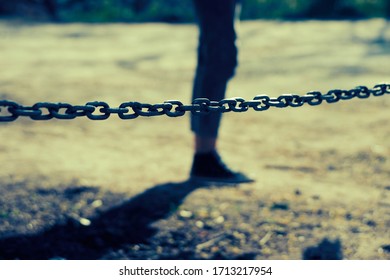 Stop Concept. Selective focus on a metal chain in front of a girl silhouette. Blurred background