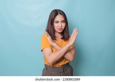 Stop. Concerned Asian Woman Showing Refusal Sign, Saying No, Raise Awareness, Standing Over Blue Background