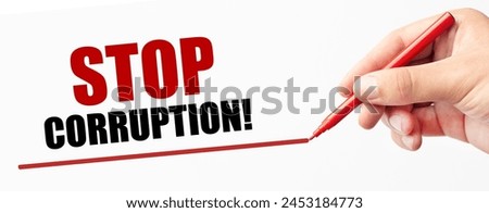 Stop Corruption slogan being written by hand with red marker. Social justice and reform concept.