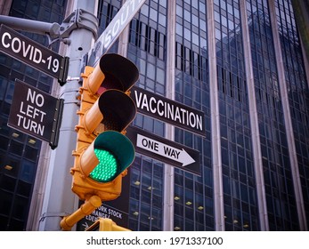 Stop Covid-19 Concept. NYC Wall Street Yellow Traffic Light With Green Light, Black Pointer Guide One Way To Vaccination Of Population. No Turn To Coronavirus And Pandemic