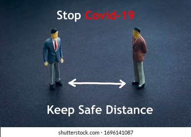 STOP COVID-19 KEEP SAFE DISTANCE text and miniature people on dark background. Covid-19 and Coronavirus concept