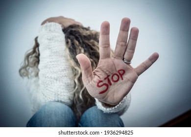 Stop crime violence abuse on women from men - woman protect herself sitting on the ground with hand to defense - home crime violence and couple abueses problems issues concept