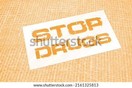 Stop drugs words on card on burlap canvas. Addictions healthcare concept.