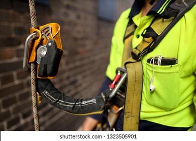 A stop fall descent self controller safety device shock absorbing lanyard attached clipping  front of rope access inspector industrial full body safety abseiling harness loop preventing from fall  

 - Shutterstock ID 1323505901