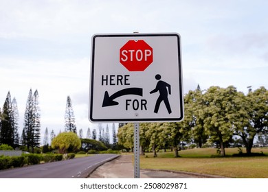 Stop Here For Pedestrians white square metal road sign on the side of a residential street - Powered by Shutterstock