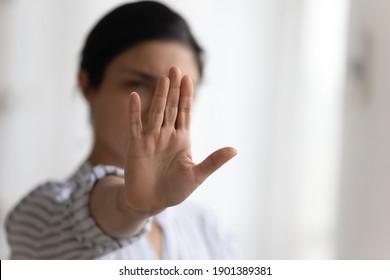 Stop it. Determined millennial lady strongly resist domestic violence against women gender discrimination bullying abuse. Focus on female palm raising up to camera in forbidding gesture. Copy space