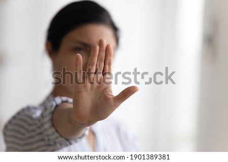 Stop it. Determined millennial lady strongly resist domestic violence against women gender discrimination bullying abuse. Focus on female palm raising up to camera in forbidding gesture. Copy space