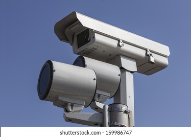 Stop light traffic camera with mounted strobe lights.