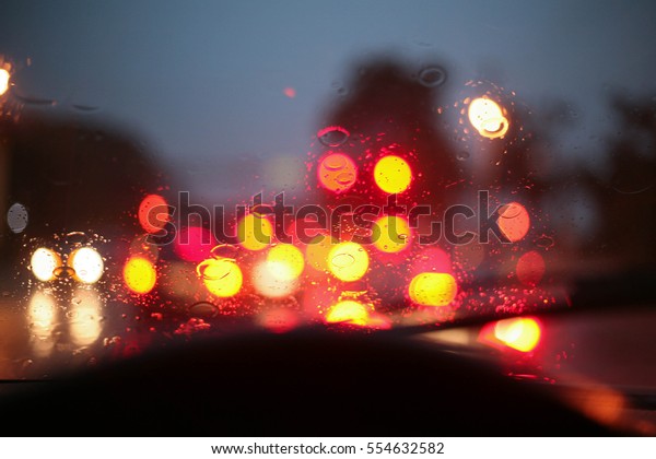 Stop lights\
in the rain at a busy intersection.\
