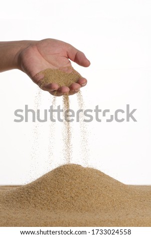 Stop motion. The male hand holds in the palm of the yellow sand. Sand flows down through your fingers. White background.