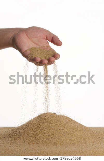 Stop\
motion. The male hand holds in the palm of the yellow sand. Sand\
flows down through your fingers. White\
background.