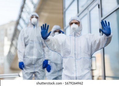 Stop, No Panic, Please. Man In Virus Protective Suit Stopping Crowd From Going Forward, Gesturing