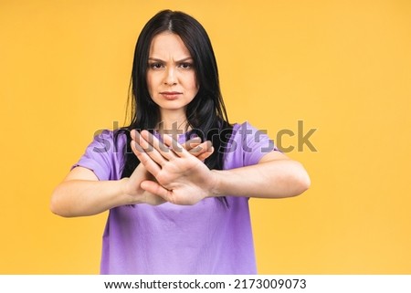 Stop or no sign! Young beautiful hispanic sad woman serious and concerned looking worried and thoughtful facial expression feeling depressed isolated over yellow background.