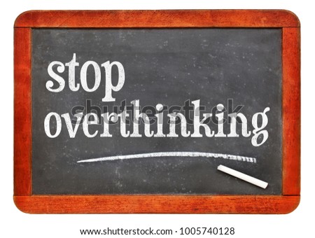 Stop overthinking - white chalk text on a vintage slate blackboard