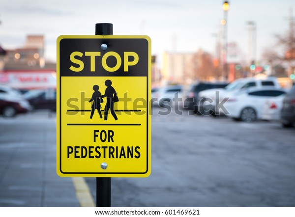 Stop for pedestrian\
sign in parking lot.