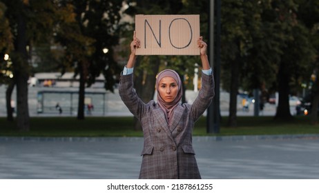 Stop Racism Concept Arab Immigrant Muslim Woman In Hijab Protests Against Discrimination Vax Vaccination Standing In City. Islamic Girl Holding Cardboard Slogan Banner With Text No Disagree Refusal